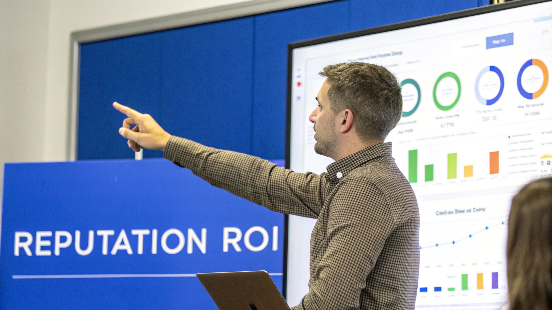 A man in a plaid shirt presents data visualizations on a large screen, explaining "REPUTATION ROI".