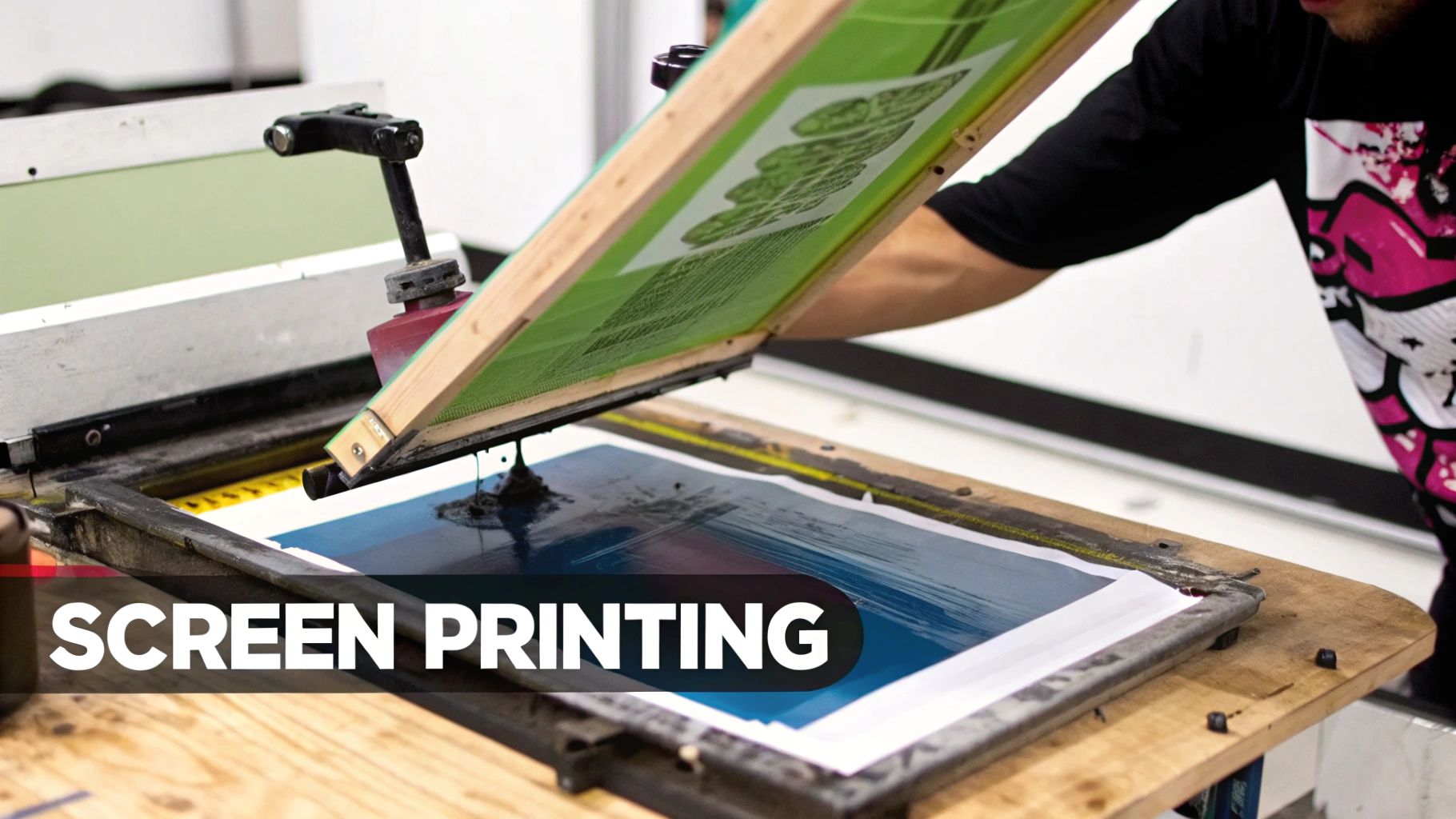 A professional screen printer applying ink to a t-shirt design