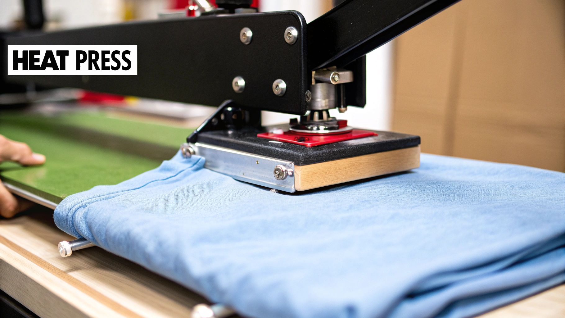 A heat press machine applying a design from transfer paper onto a white t-shirt.