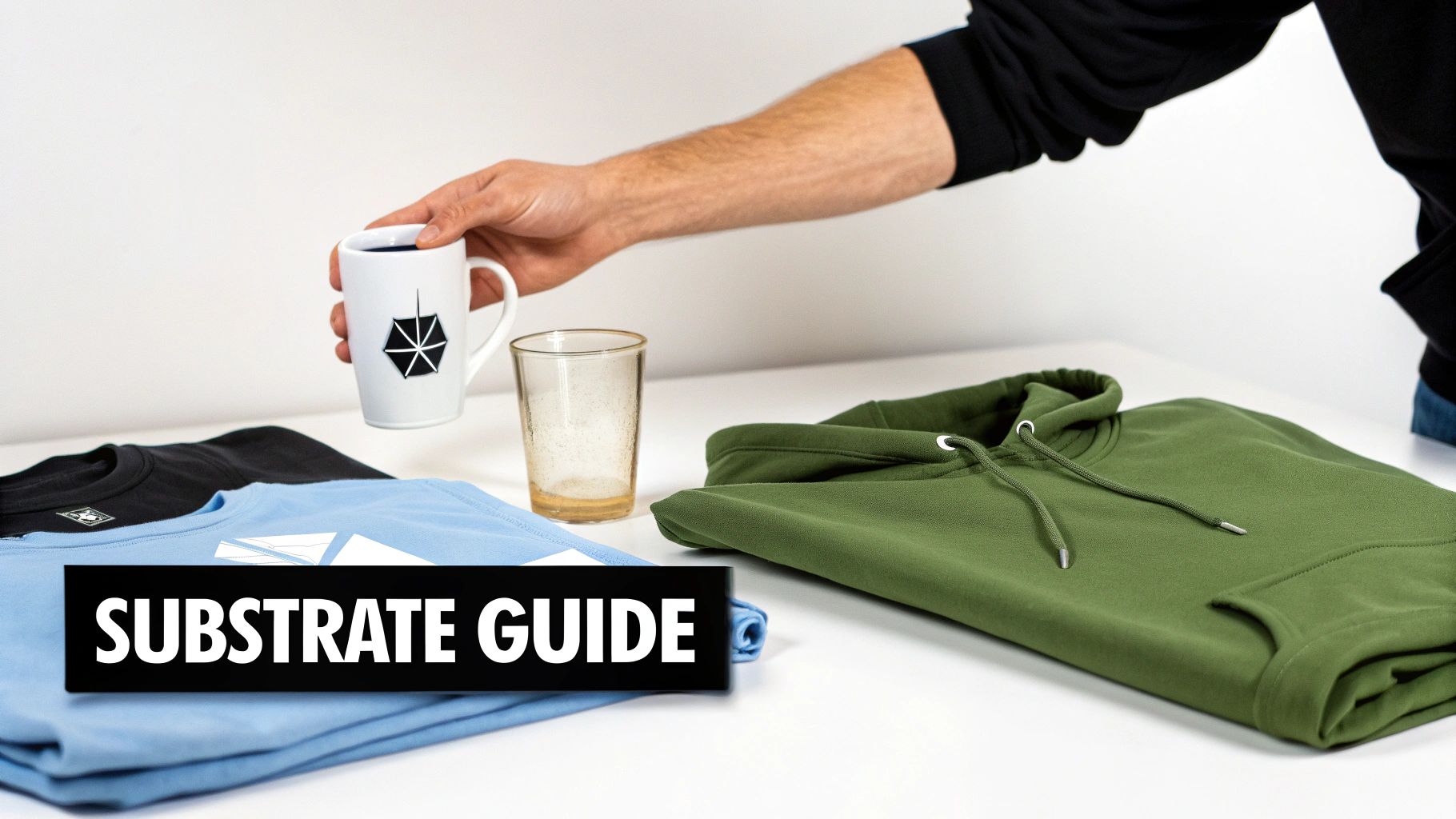 A hand holds a white mug above folded t-shirts and a green hoodie, featuring a "SUBSTRATE GUIDE" banner.