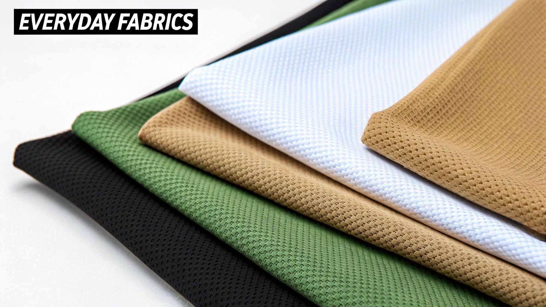 A stack of everyday fabrics in black, green, beige, white, and light brown colors.