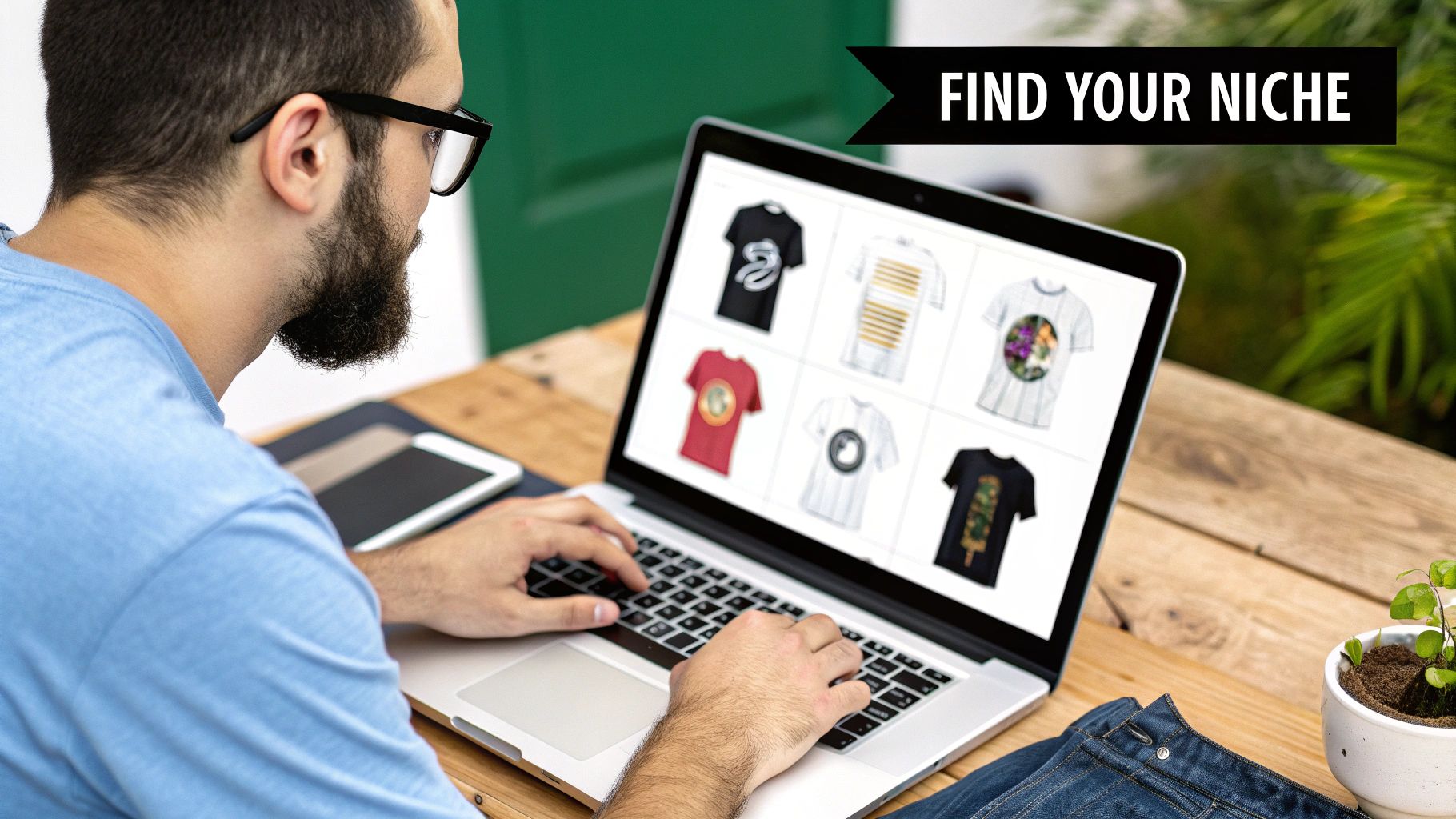 A person wearing a custom-designed t-shirt, working in a creative studio with more shirts in the background.