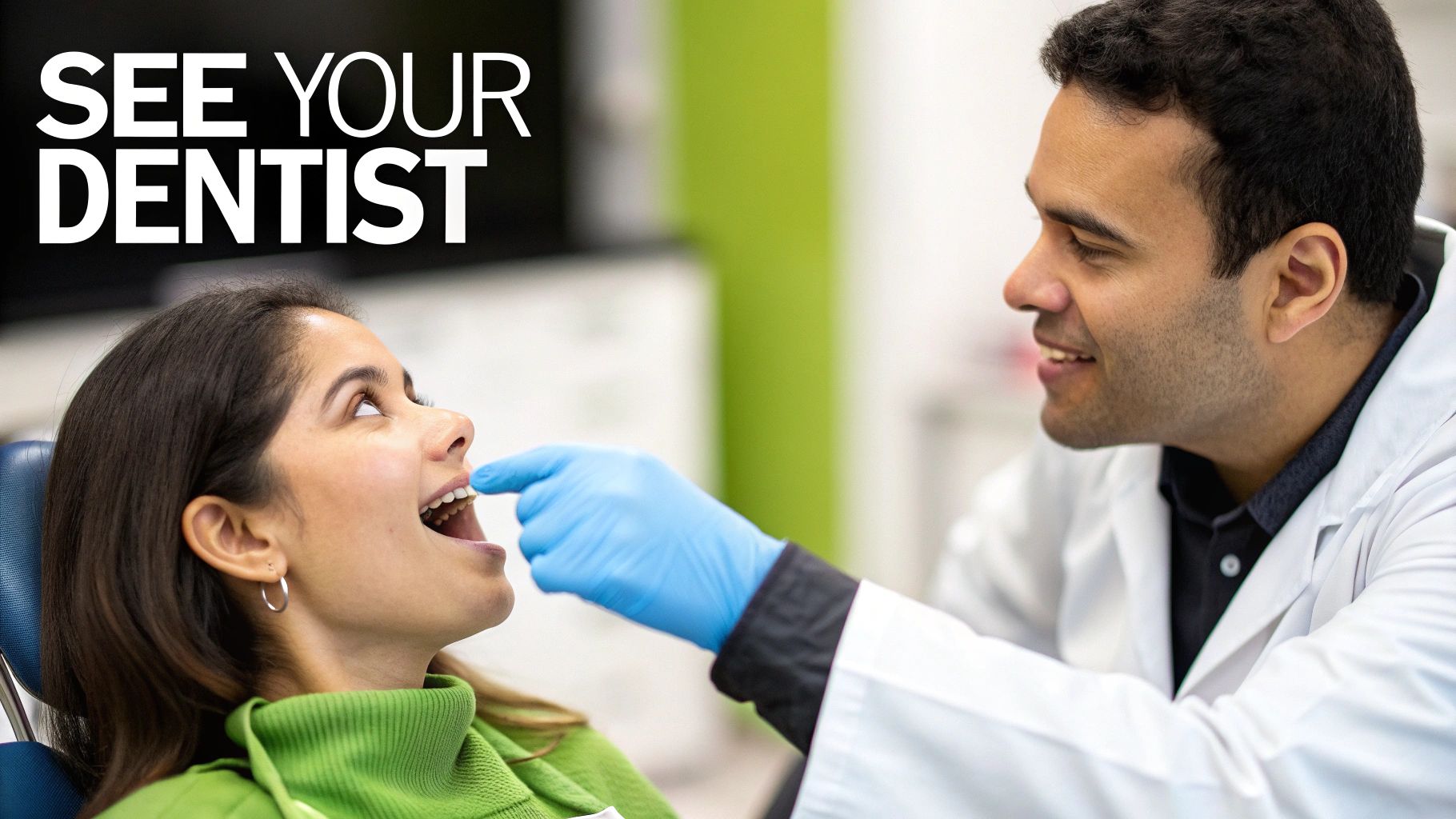 A smiling male dentist in a white coat examines a female patient's teeth during a check-up.