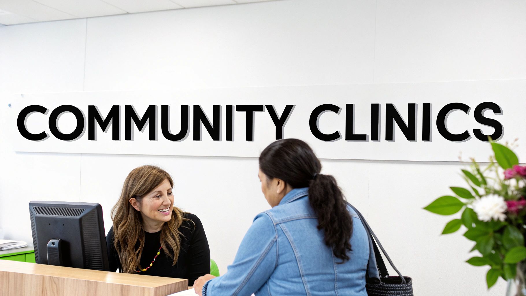 A friendly dentist reviewing a patient's chart in a community clinic setting.