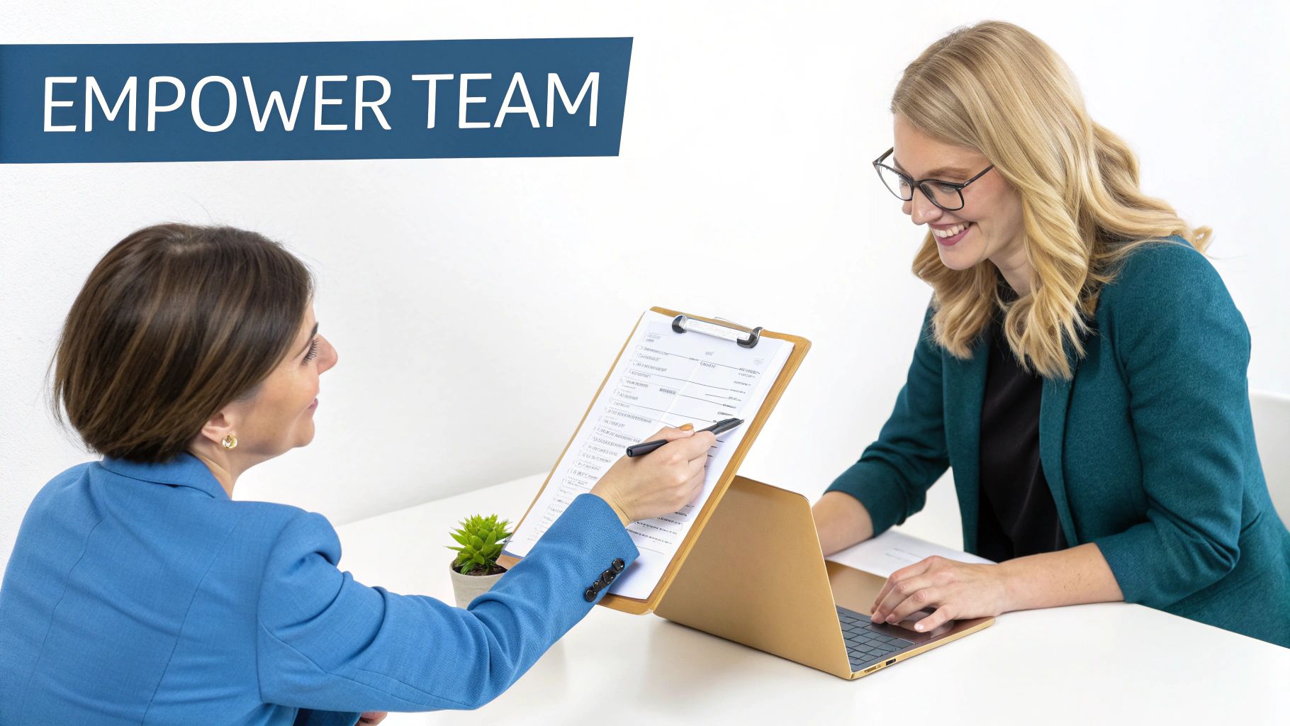 Two professional women collaborate, reviewing a document on a clipboard during a team meeting.