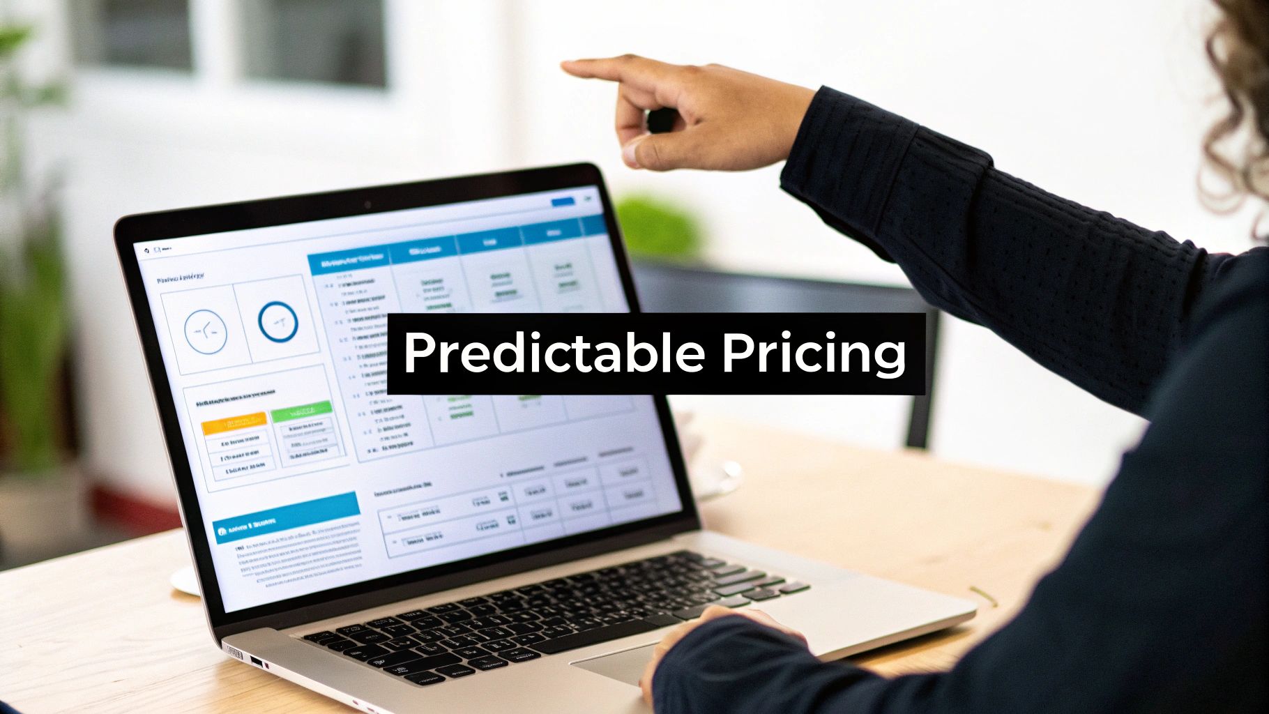 A person points at a laptop screen showing a dashboard with the text "Predictable Pricing".
