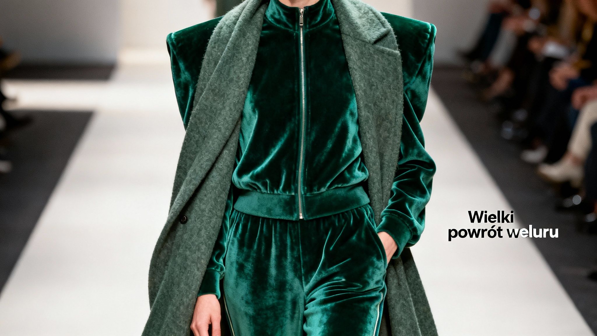 Modelka w ciemnozielonym welurowym dresie i wełnianym płaszczu na wybiegu, ukazując powrót weluru do mody.