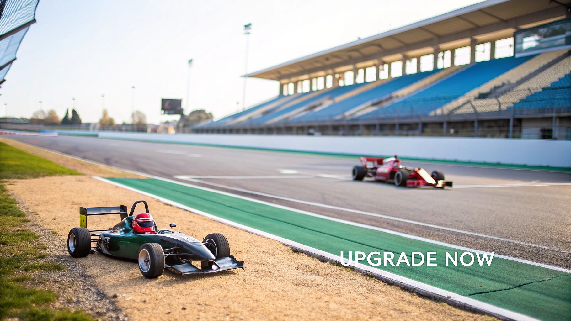 A green formula race car parked on the side of a race track, with a red car speeding past and empty grandstands in the background.