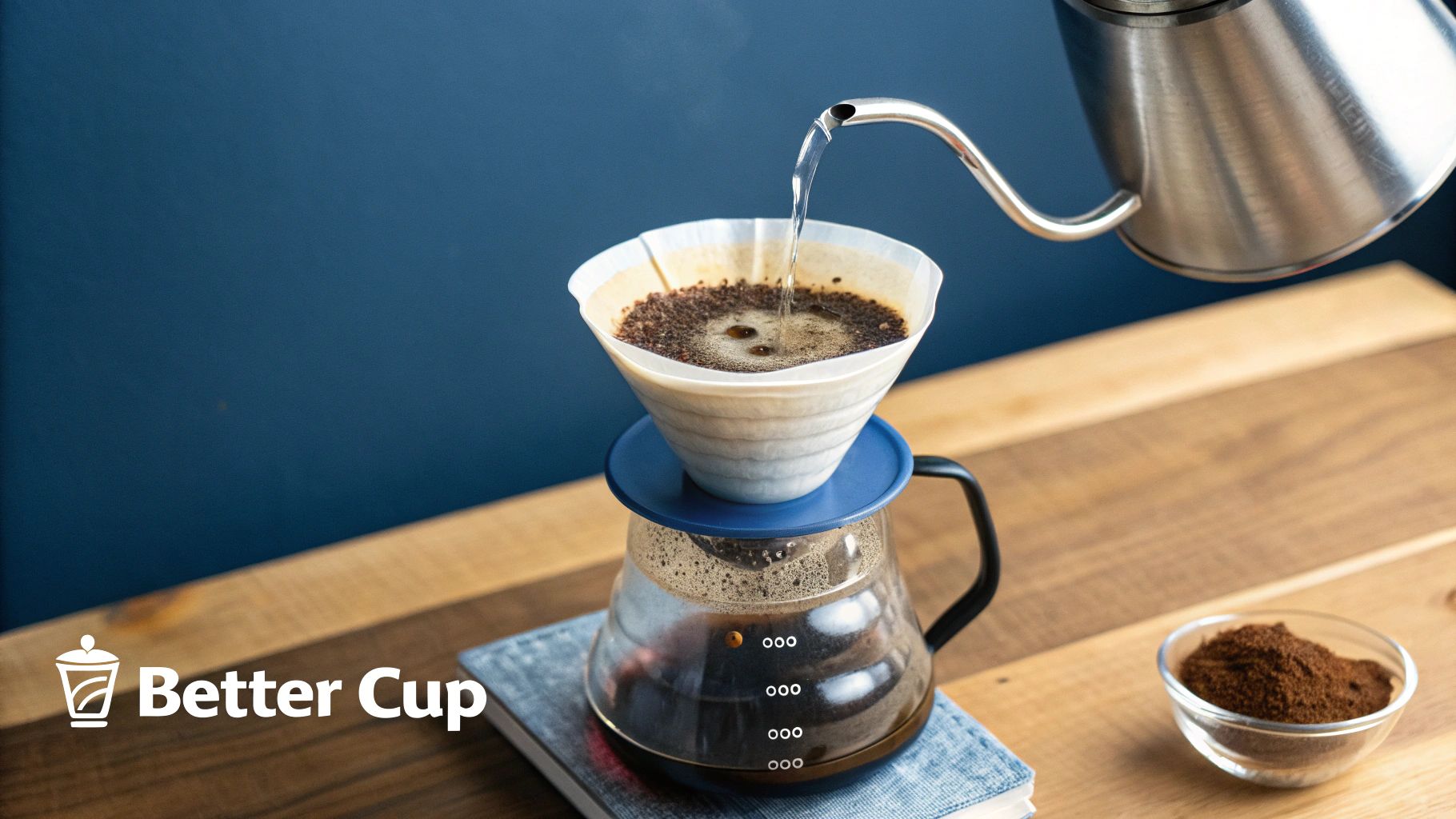 A close-up of hot water being poured over coffee grounds in a pour-over dripper.