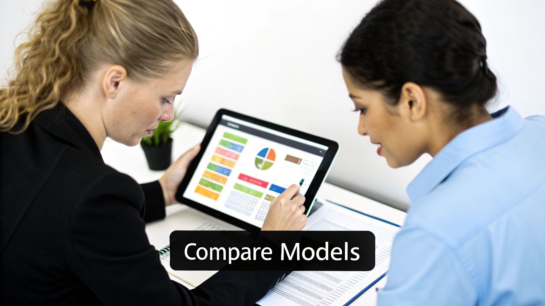 Business professionals collaborate, analyzing charts and comparing models on a tablet device.