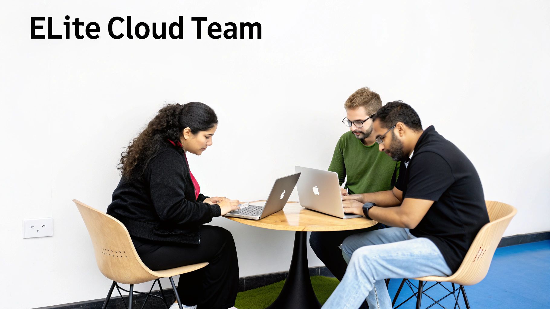 Three people from the ELite Cloud Team working together on laptops at a table.