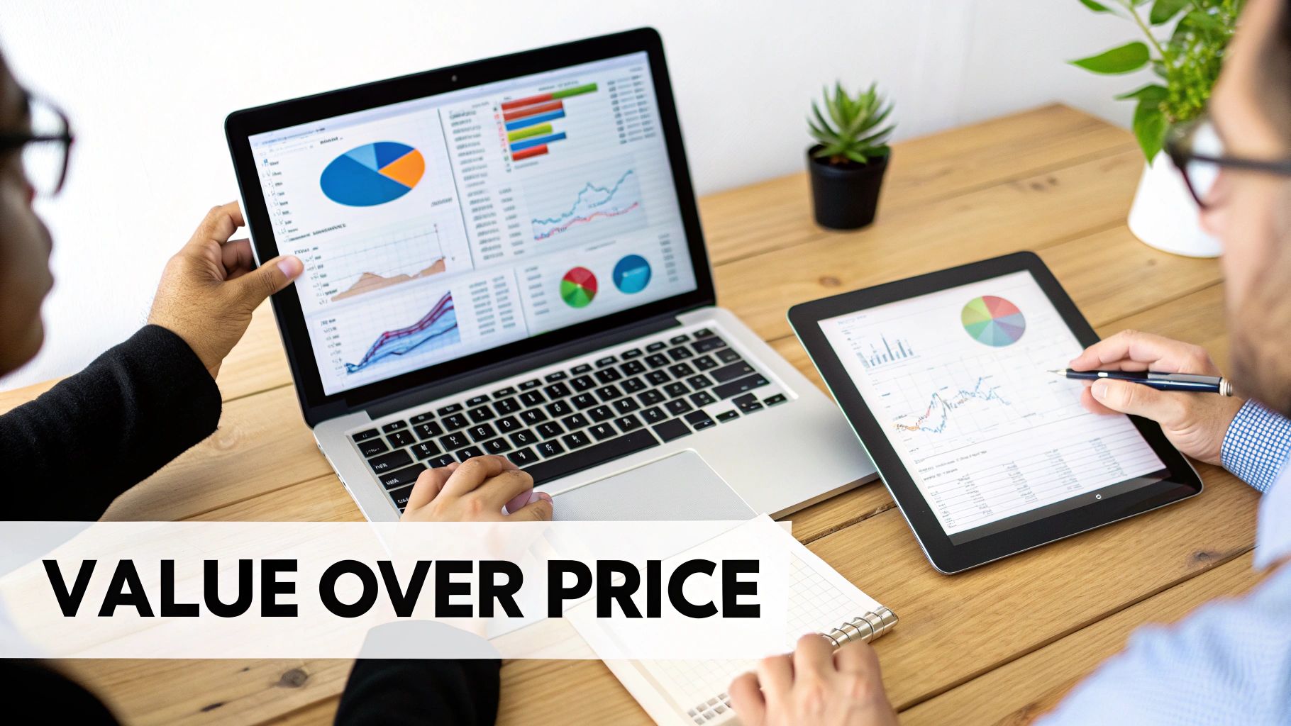 Two individuals discussing business data displayed on a laptop and a digital tablet.