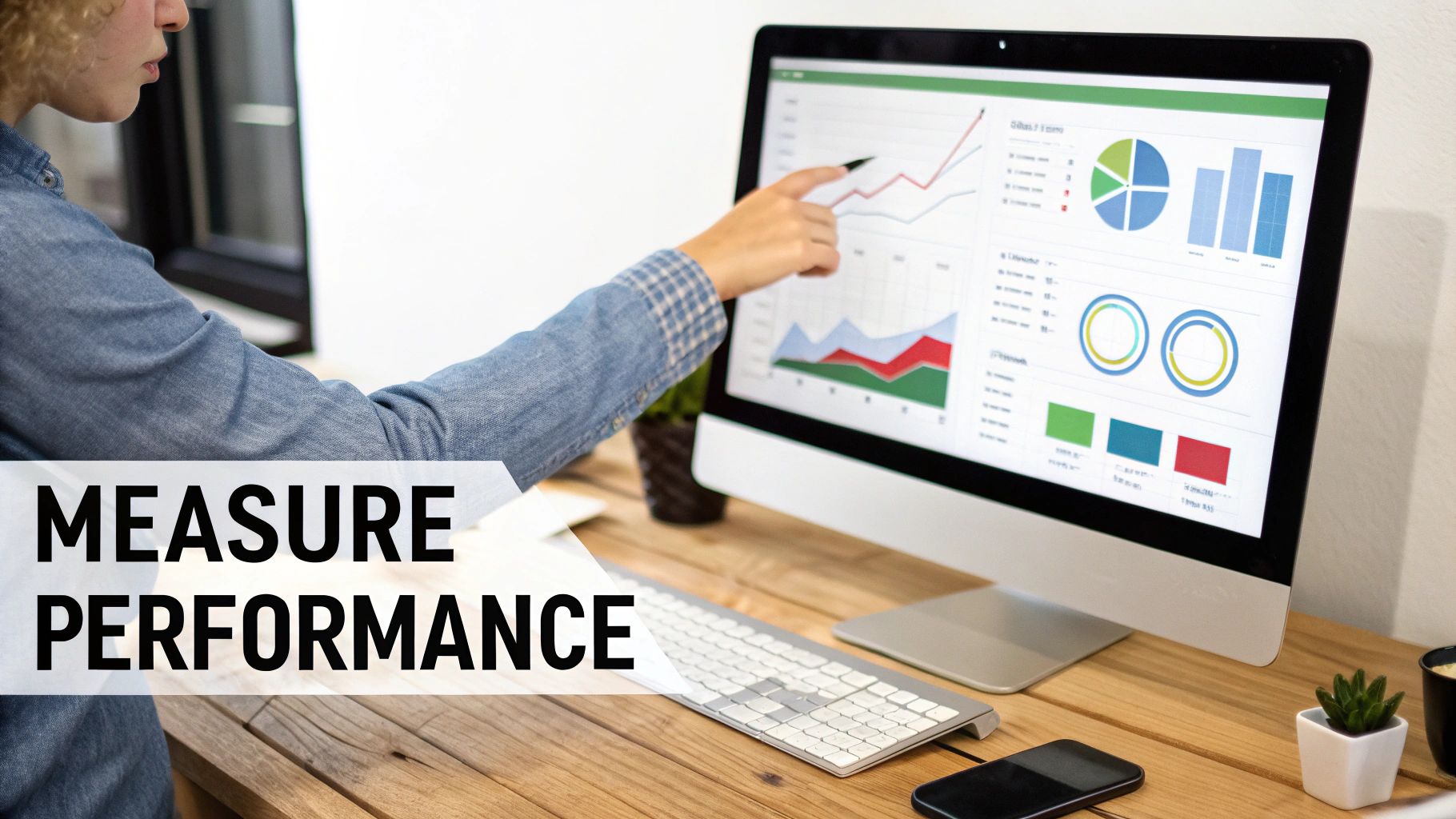 A person points at a computer screen displaying business performance graphs and charts, with 'MEASURE PERFORMANCE' text.