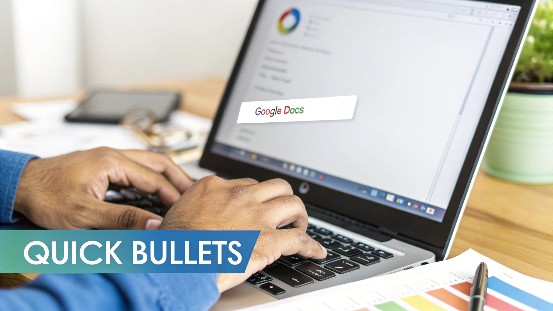 A person types on a laptop displaying Google Docs, with a pen and documents on the wooden desk.