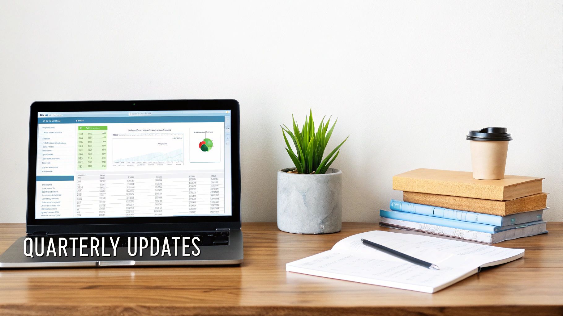A business desk setup with a laptop displaying charts and 'QUARTERLY UPDATES', a plant, books, and a coffee cup.