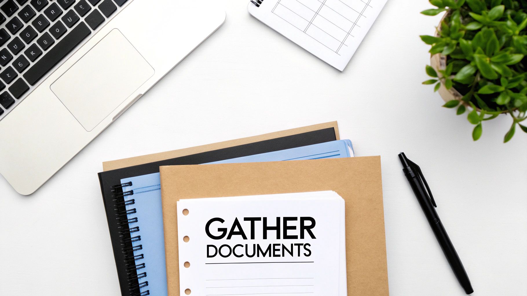 A person at a desk neatly organising financial documents into folders, giving a sense of control and readiness.