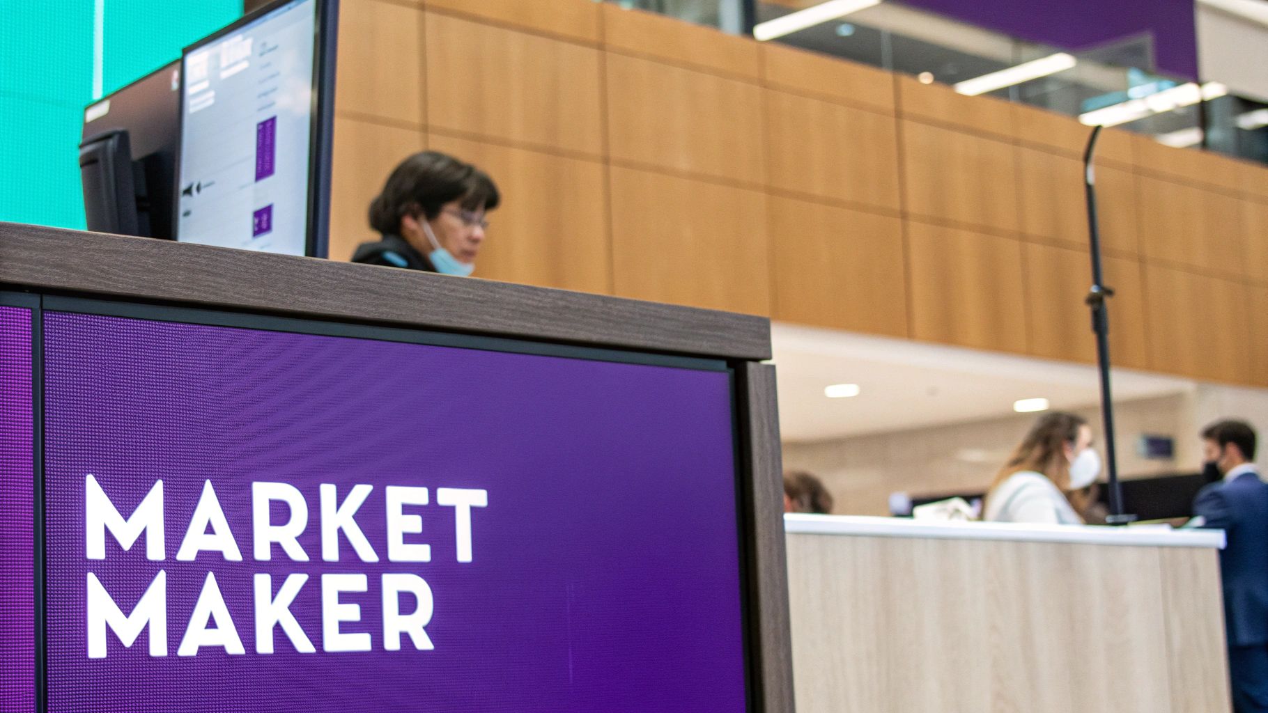 A person at a desk with multiple monitors showing financial charts and data