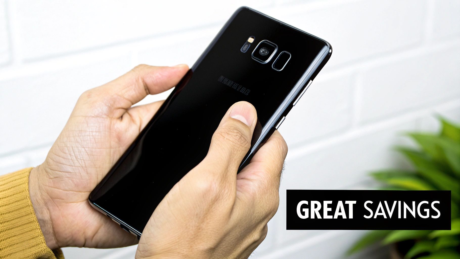 A person holding up a refurbished Samsung Galaxy phone with a green leaf symbol on the screen, representing its eco-friendly benefit.