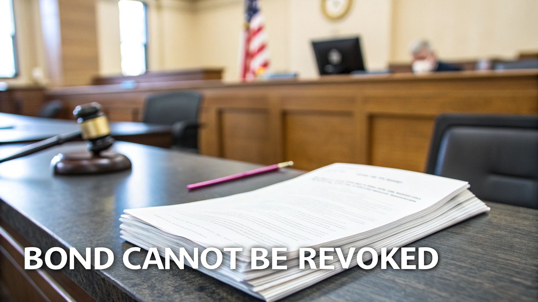 A gavel and legal documents on a table in a courtroom, with an American flag in the background.