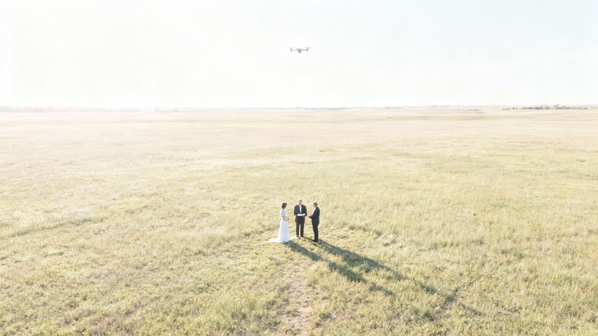 A couple celebrating their wedding in a picturesque outdoor setting, with a drone visible in the sky above.