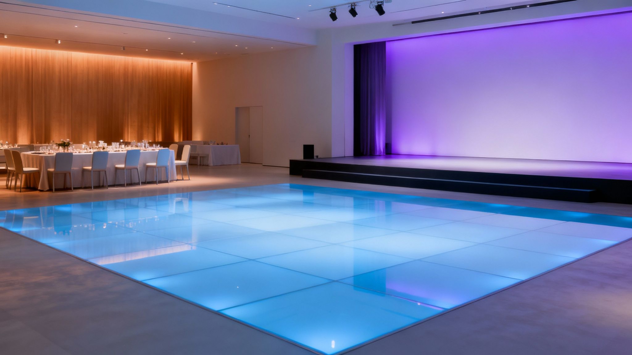 A wedding reception hall with warm amber LED uplights creating an elegant atmosphere.