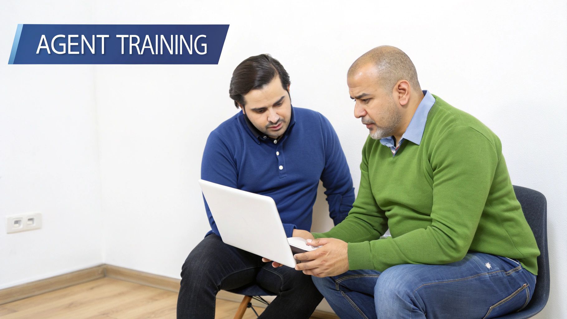 Two diverse men are engaged in an agent training session, focusing on a laptop screen.