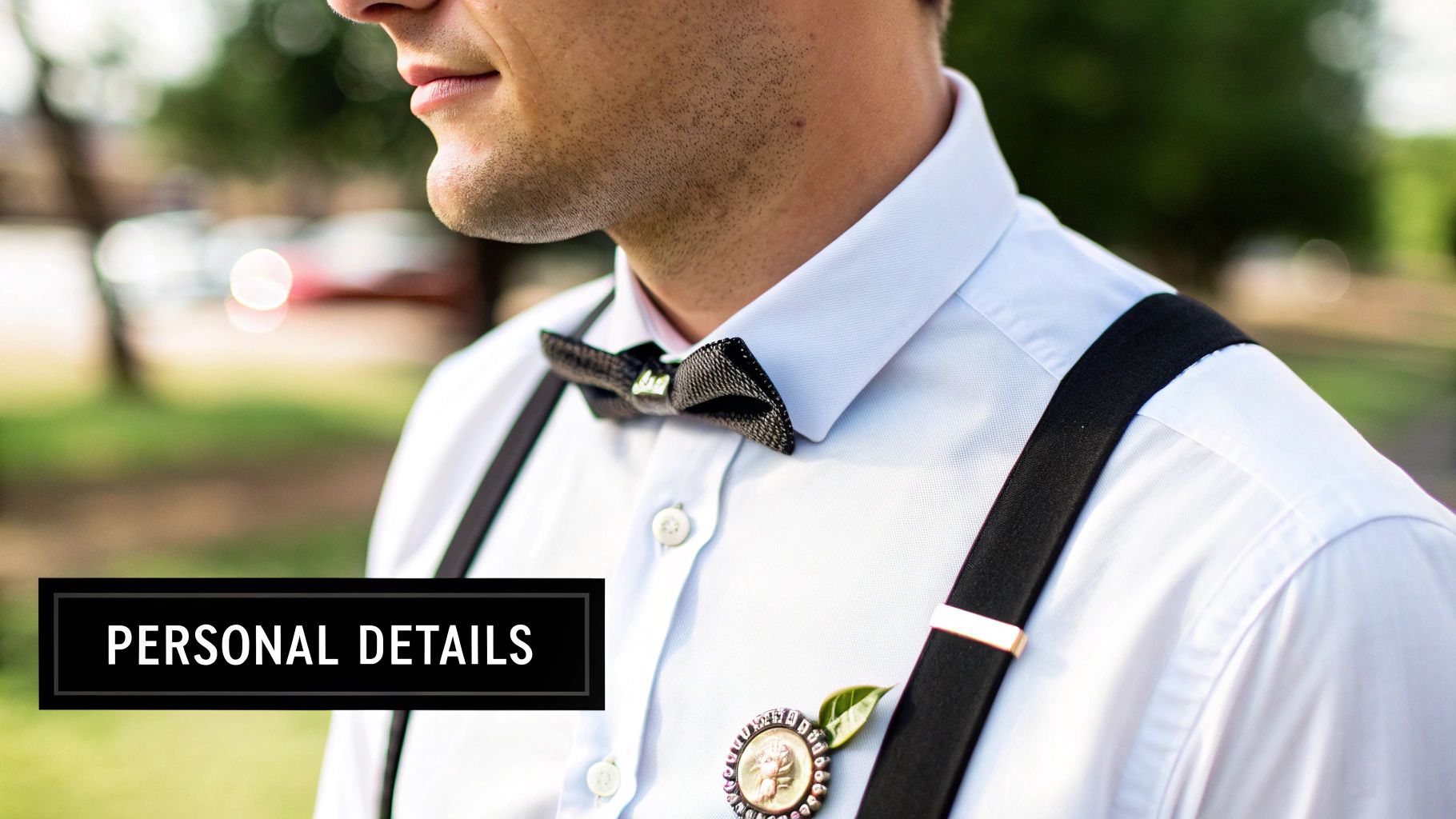 Close-up of a stylish man in a white shirt, black bow tie, and suspenders with a unique lapel pin.