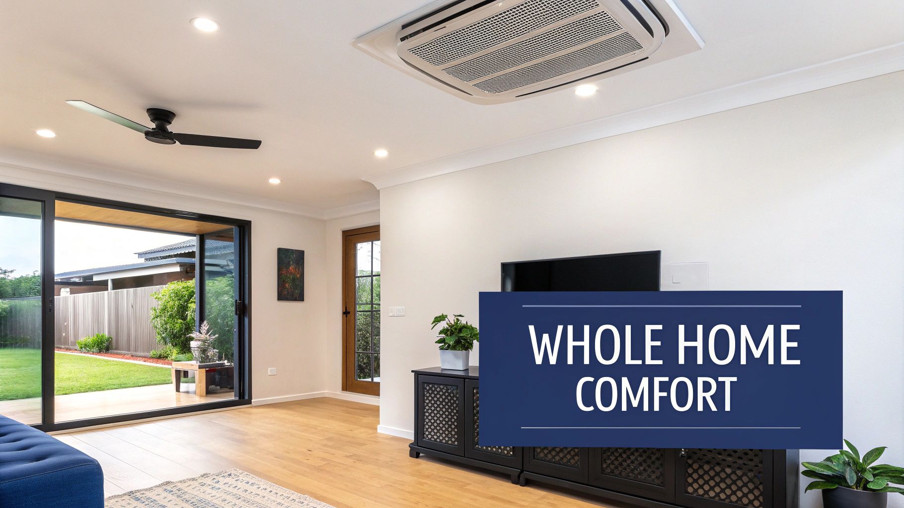 A modern living room with a ceiling-mounted air conditioner, a fan, and a view of the backyard.