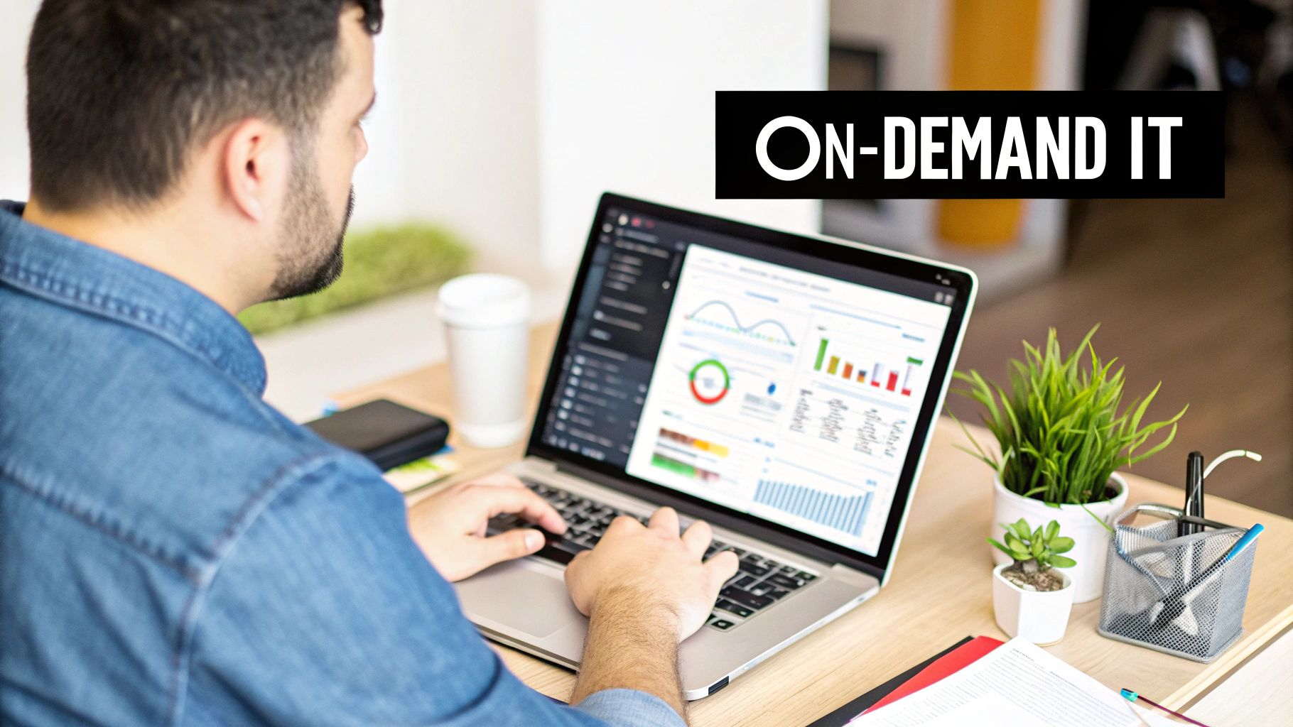 Man working on a laptop with data charts on screen, alongside an 'ON-DEMAND IT' banner.