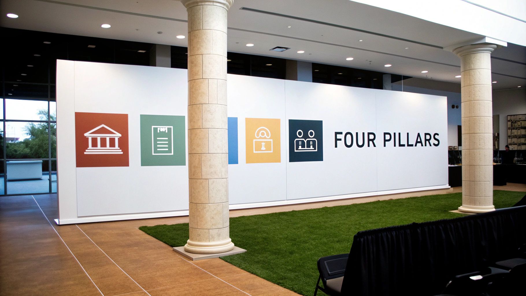 A large white display wall showcasing four colorful square icons and the text 'FOUR PILLARS'.