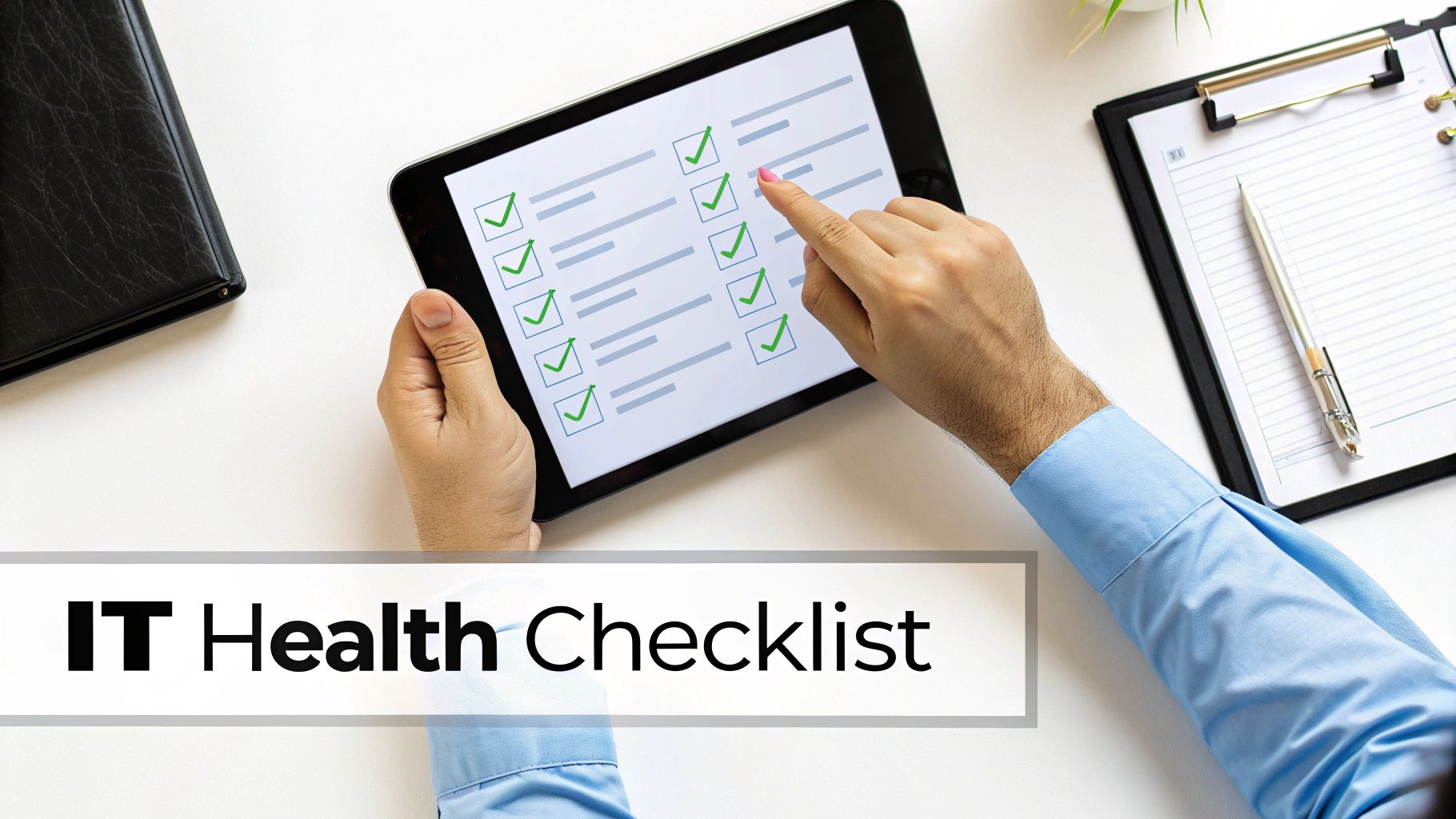 Overhead view of hands tapping an IT Health Checklist on a tablet, with other office items.