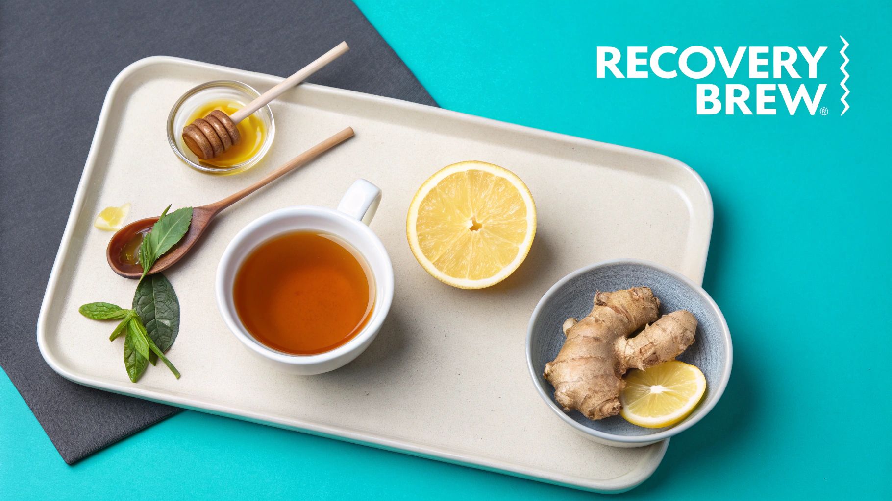A tray with a cup of tea, lemon, ginger, honey, and fresh mint leaves for a recovery brew.