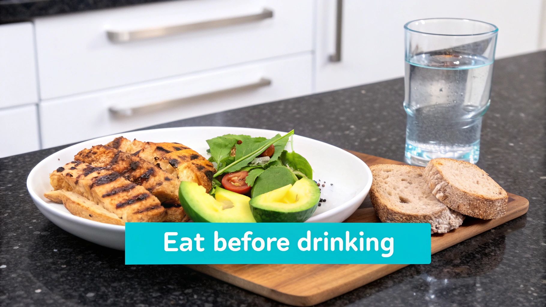 A healthy meal with grilled chicken, salad, avocado, bread, and water on a kitchen counter.