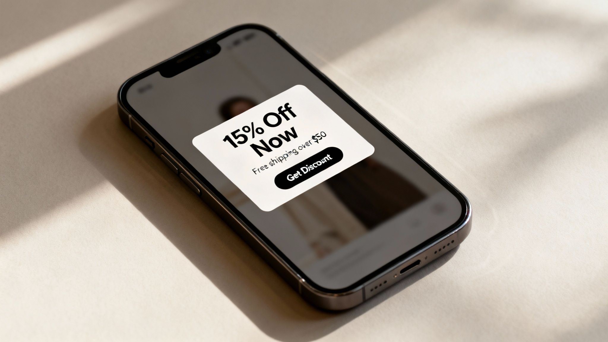 Close-up of a smartphone screen showing a discount pop-up, promoting 15% off and free shipping.