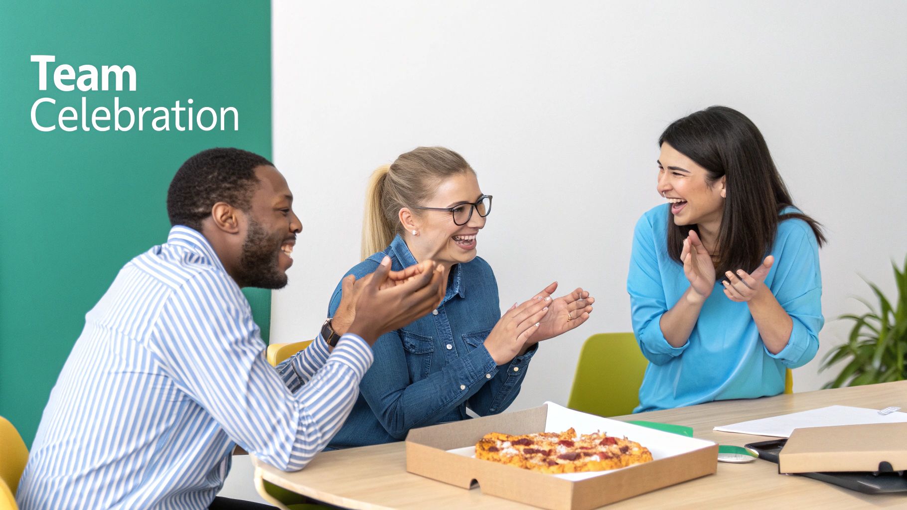 Three diverse colleagues celebrating a team event with pizza, laughing and clapping enthusiastically at a table.
