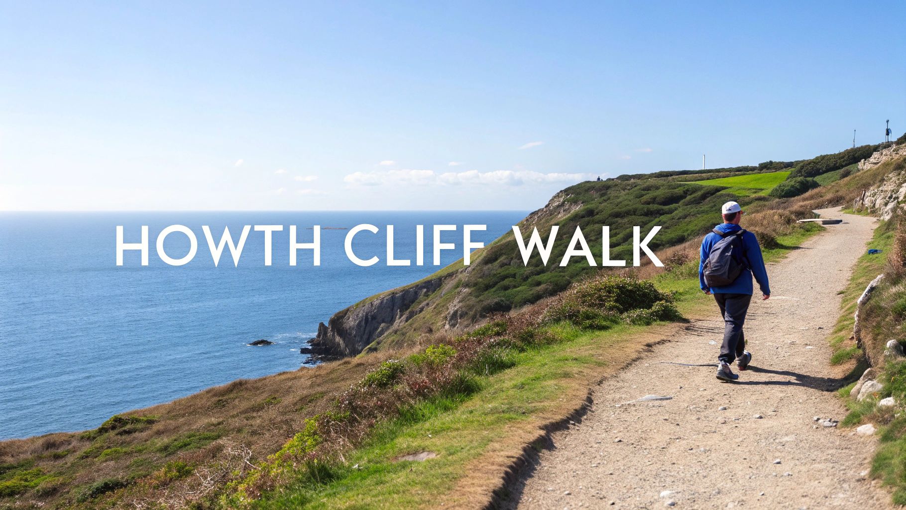 A person walks on a scenic cliff path overlooking the blue ocean on a sunny day.