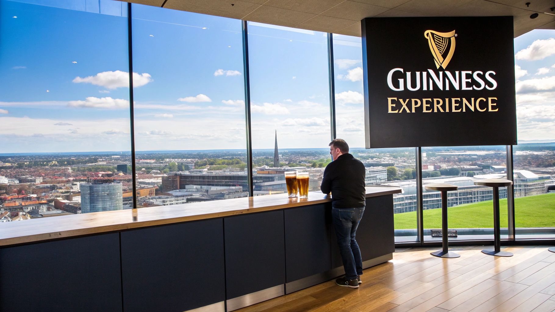 Man viewing Dublin cityscape with two pints of Guinness on a counter at the Guinness Experience.