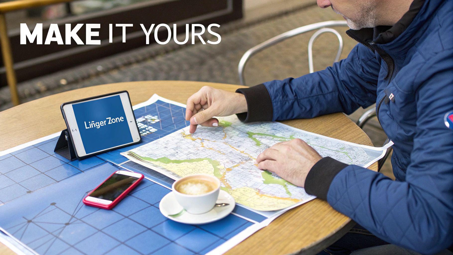 A person planning a trip, looking at a map on a table with a tablet and coffee.