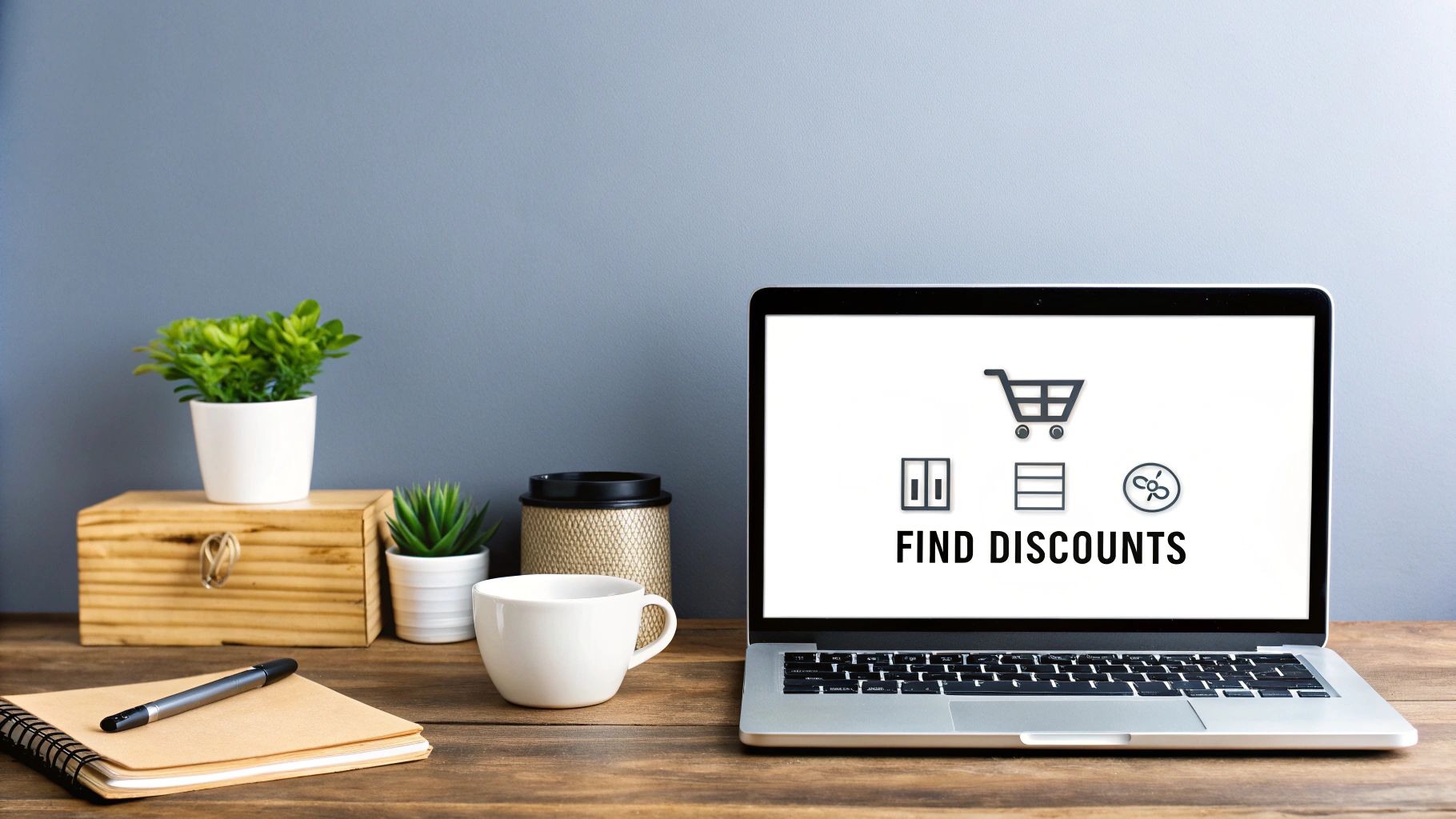 Laptop displaying find discounts text with shopping cart icon on wooden desk workspace