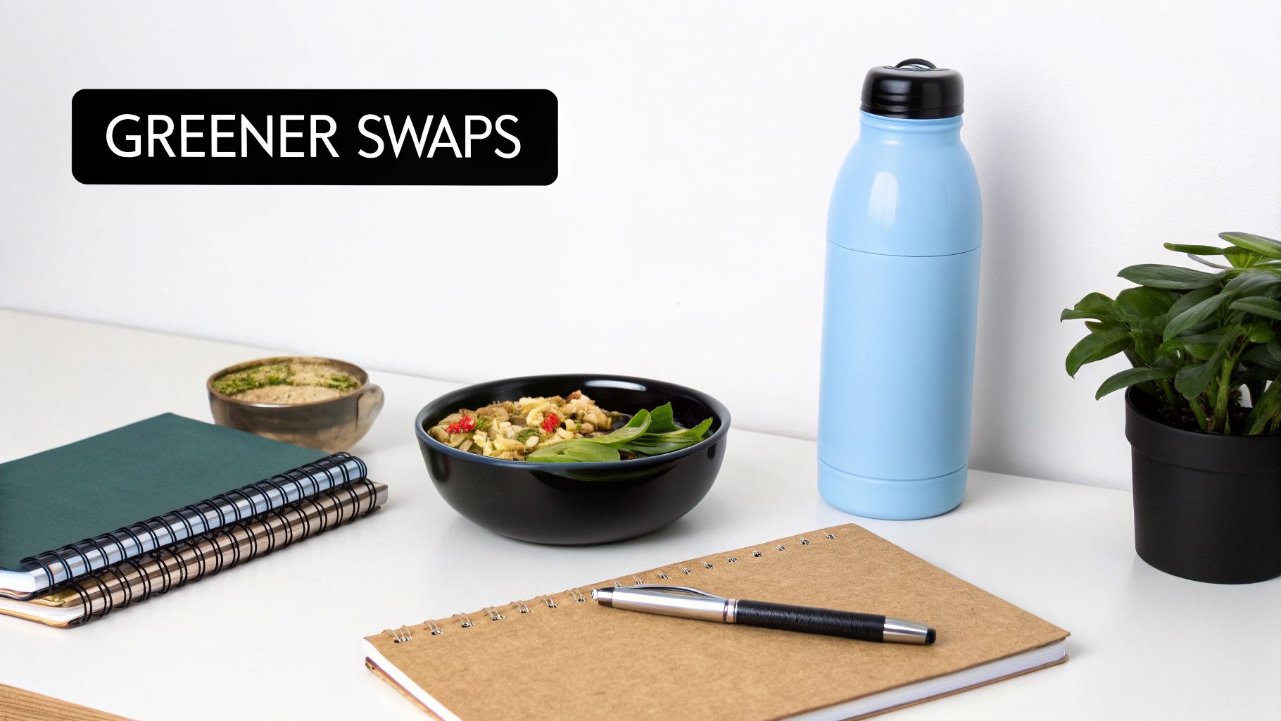 An office desk with 'Greener Swaps' sign, reusable water bottle, healthy food, notebooks, and a plant.