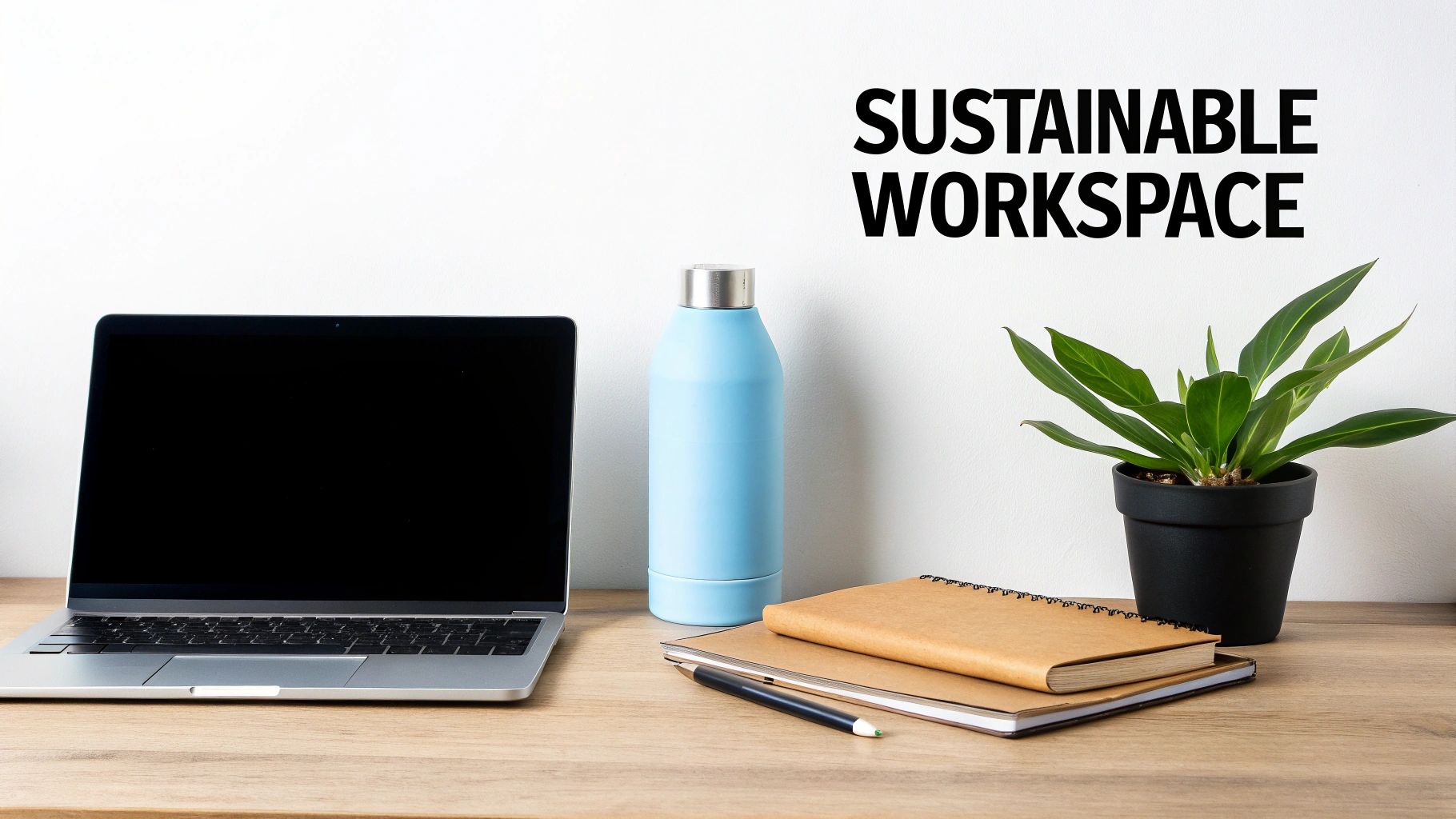 A sustainable workspace with a laptop, reusable water bottle, notebooks, pen, and a plant on a wooden desk.