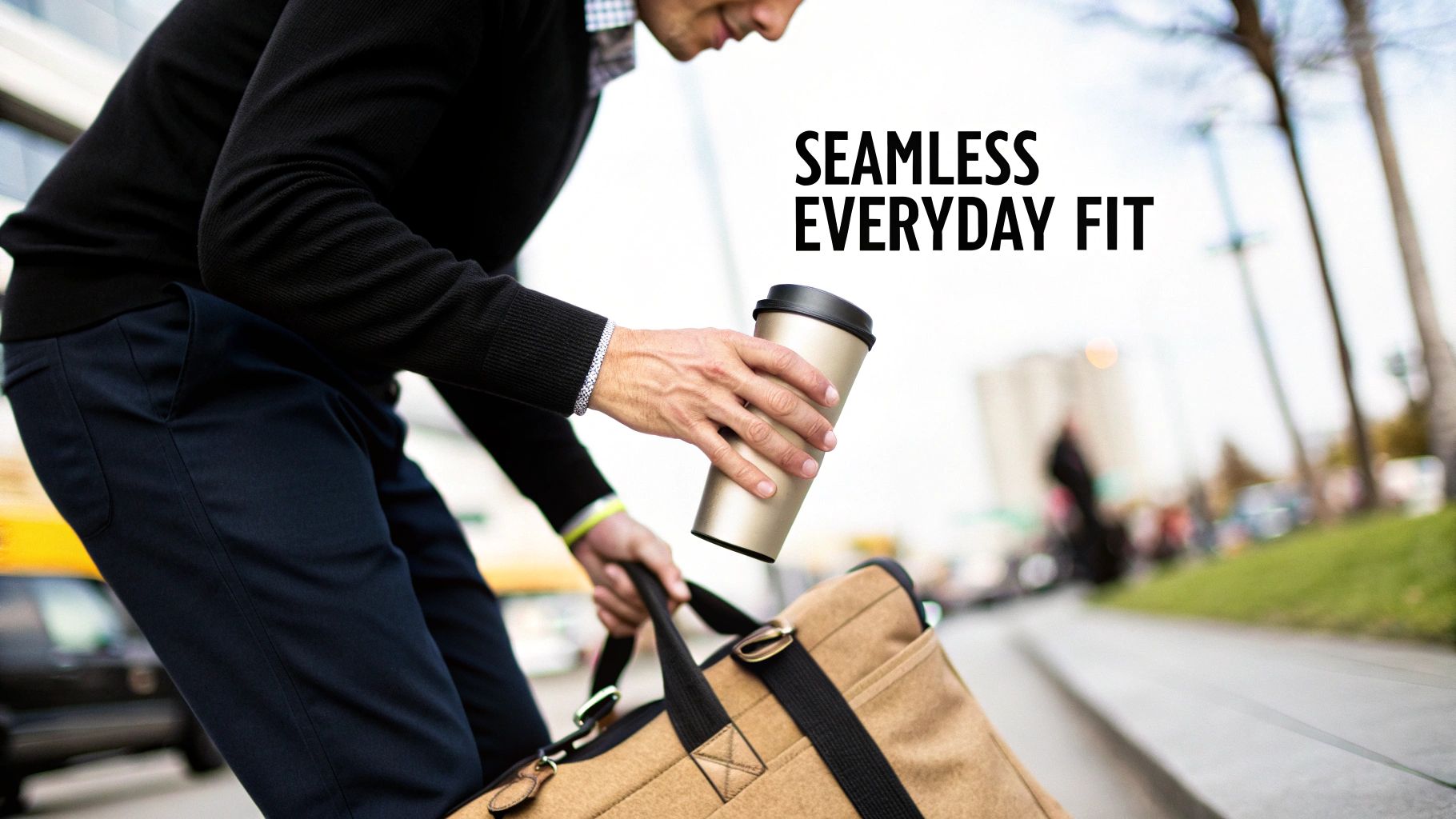 A person using a pink HYDAWAY collapsible travel cup on a city street.
