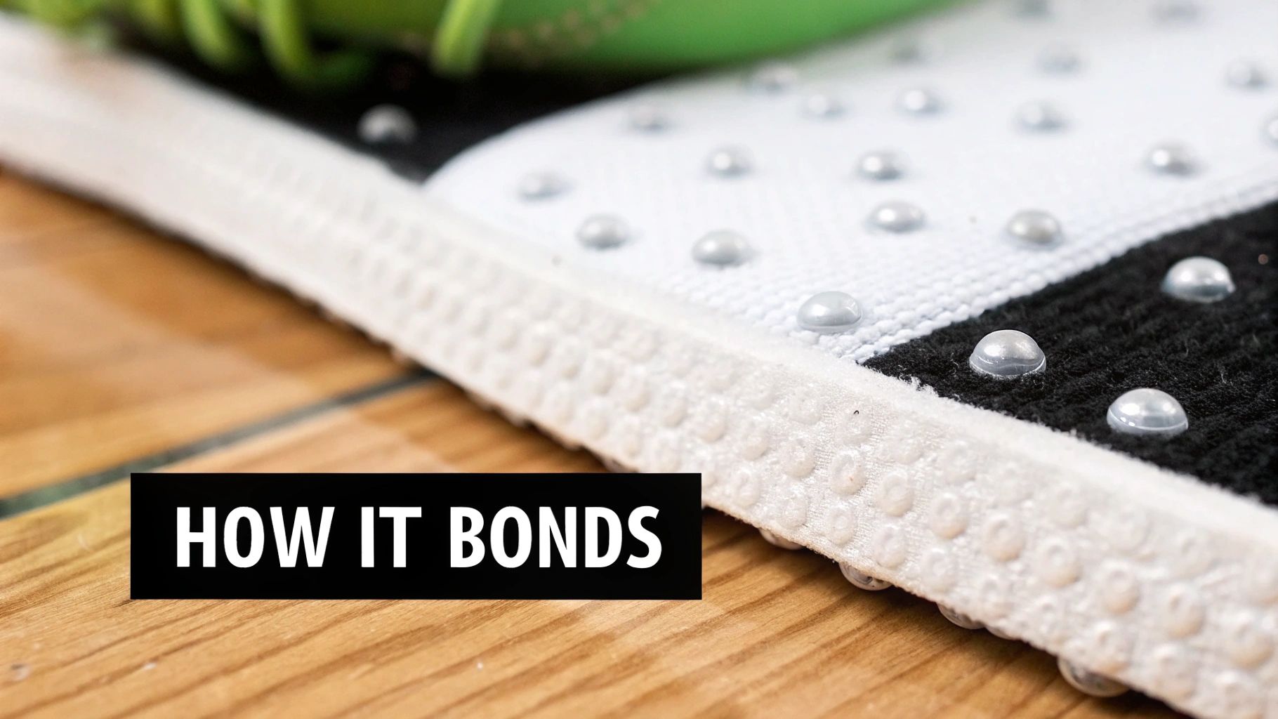 Close-up of a rug or mat with a textured white border and anti-slip dots on white and black fabric.