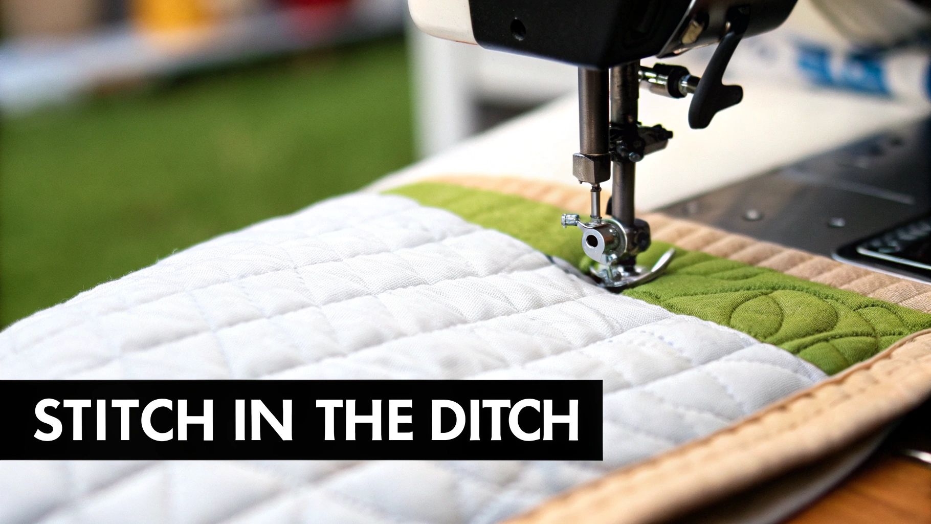A close-up of a quilt showing the subtle stitch in the ditch technique along the seam lines of colorful fabric blocks.