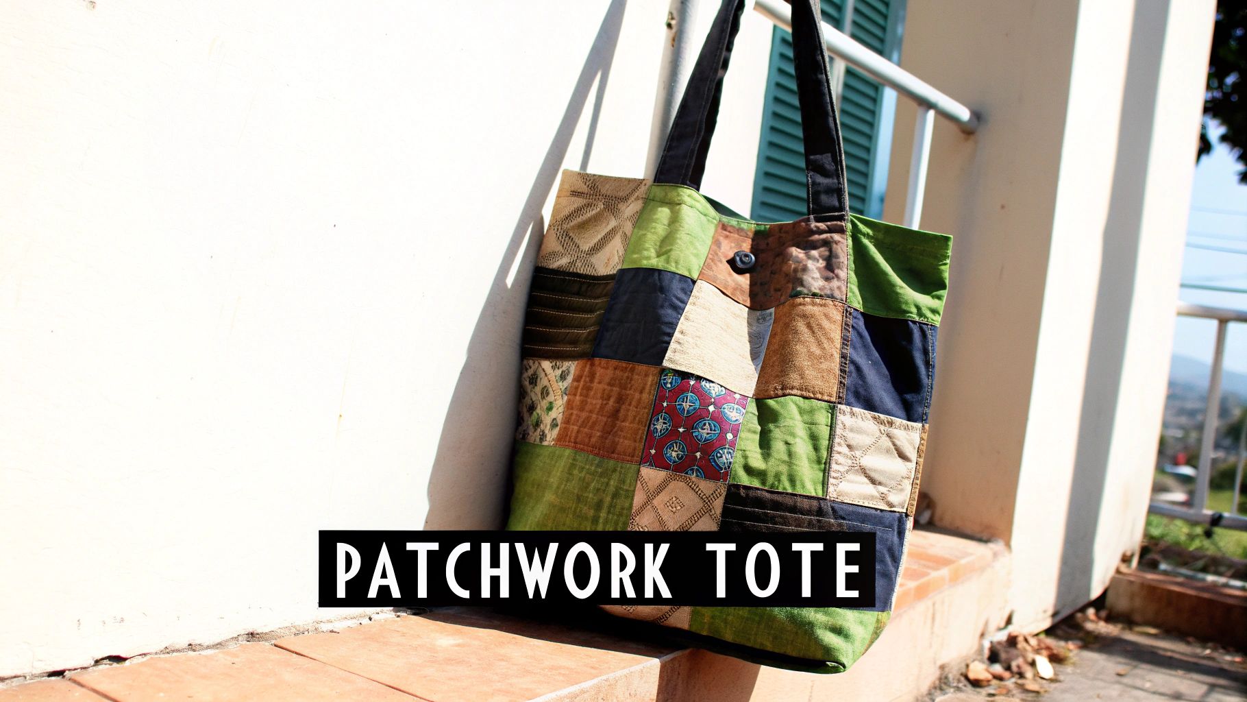 A colorful patchwork tote bag made from fabric scraps hangs on a wall outdoors.