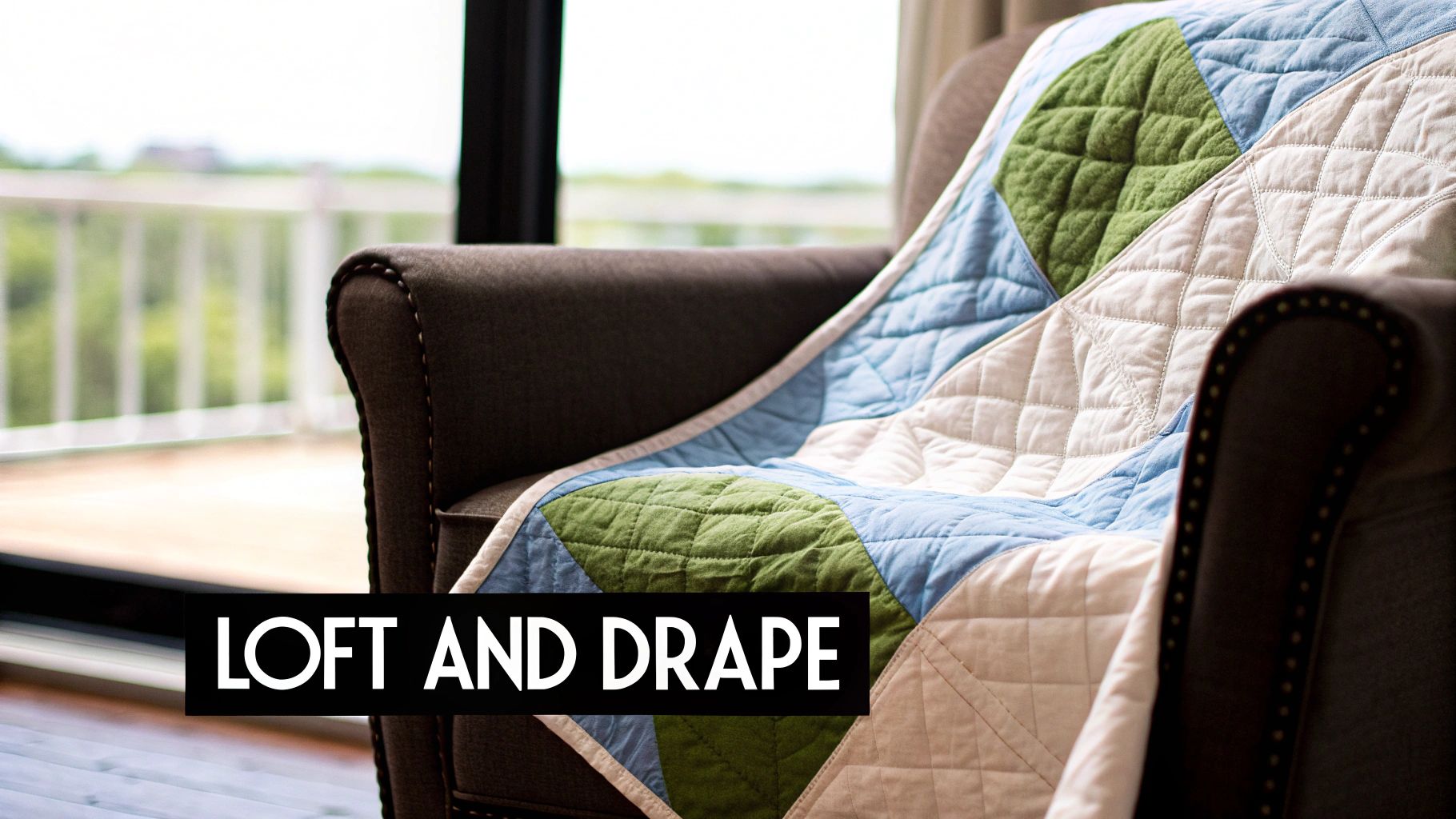 A cozy quilted blanket in green, blue, and cream draped over a dark armchair indoors.