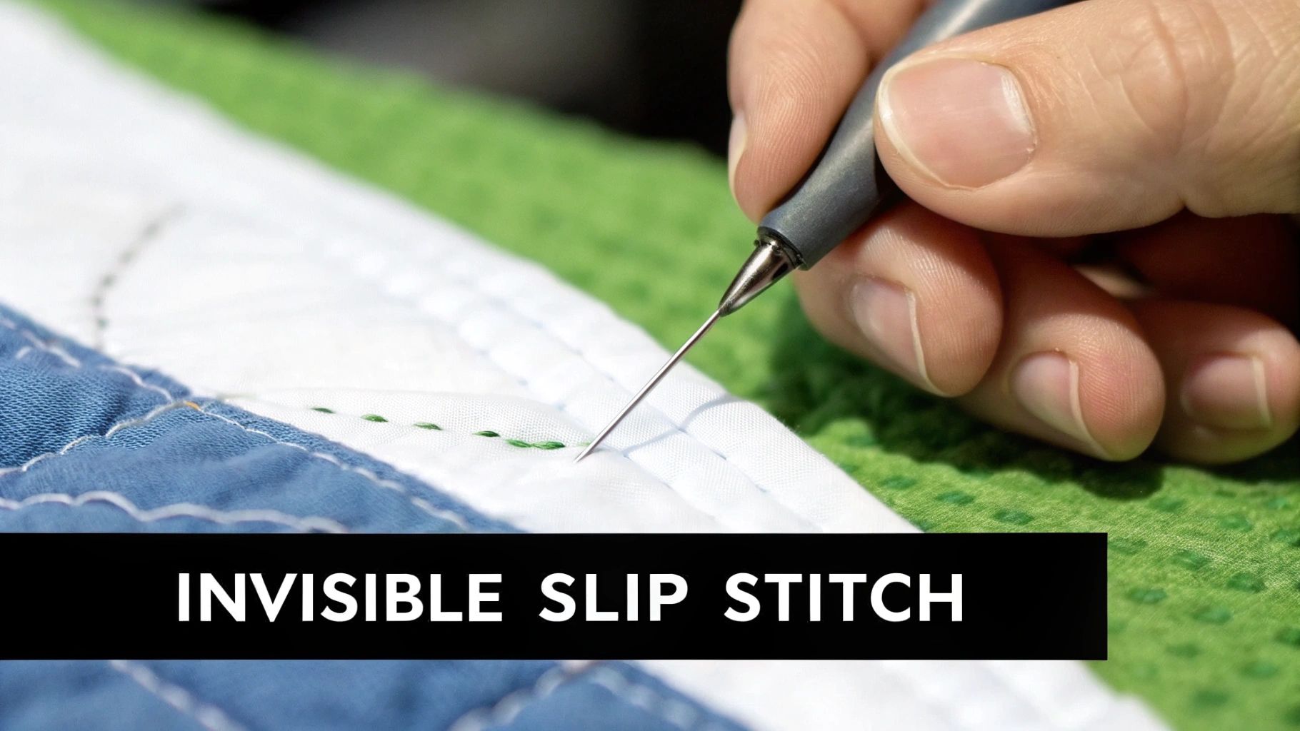 A person uses a stiletto to guide an invisible slip stitch on white quilted fabric, demonstrating a sewing technique.
