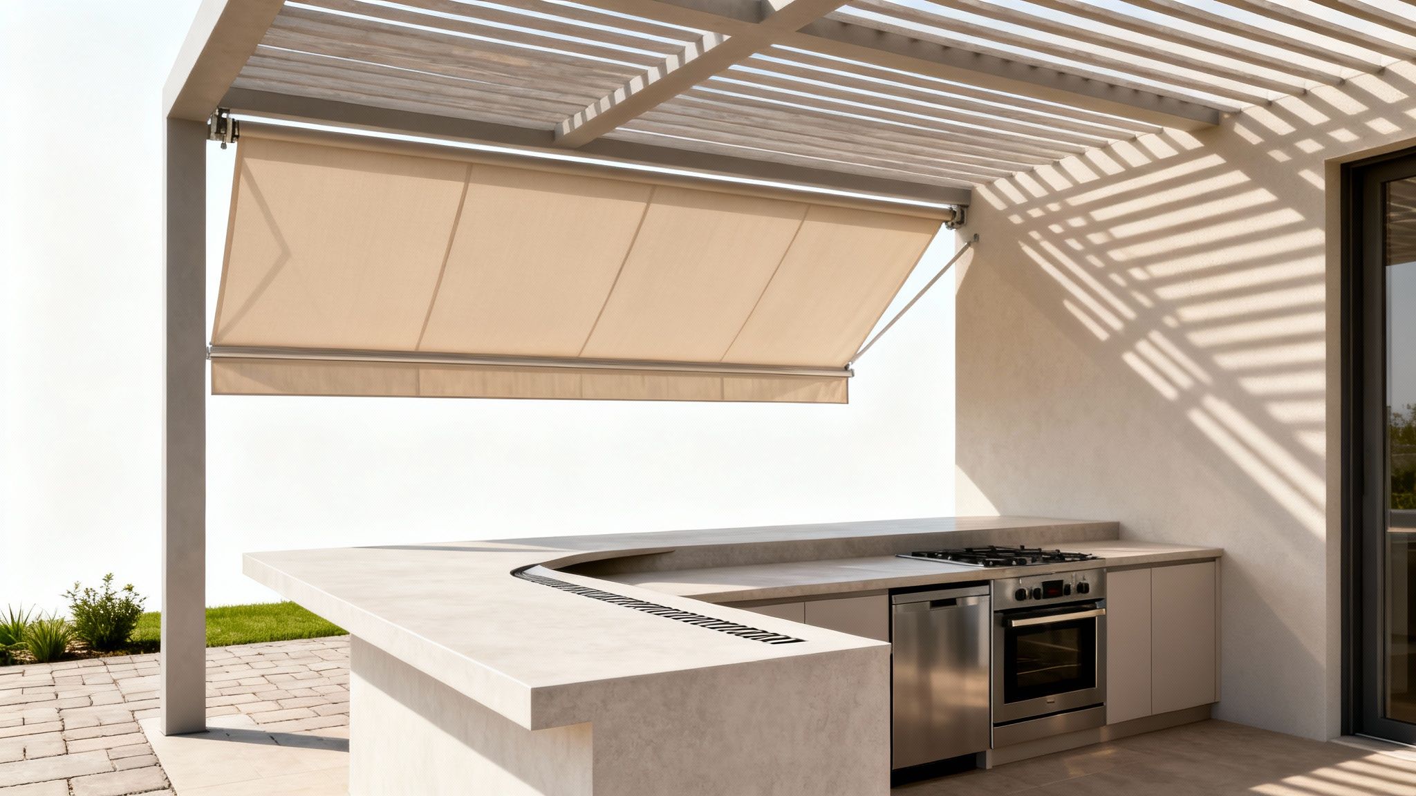 Modern outdoor kitchen with beige retractable awning under a pergola, featuring a gas stove and oven.