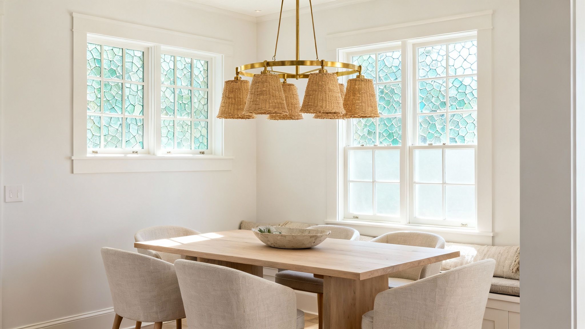 A modern chandelier hanging over a dining room table, illuminating the space with a warm glow.