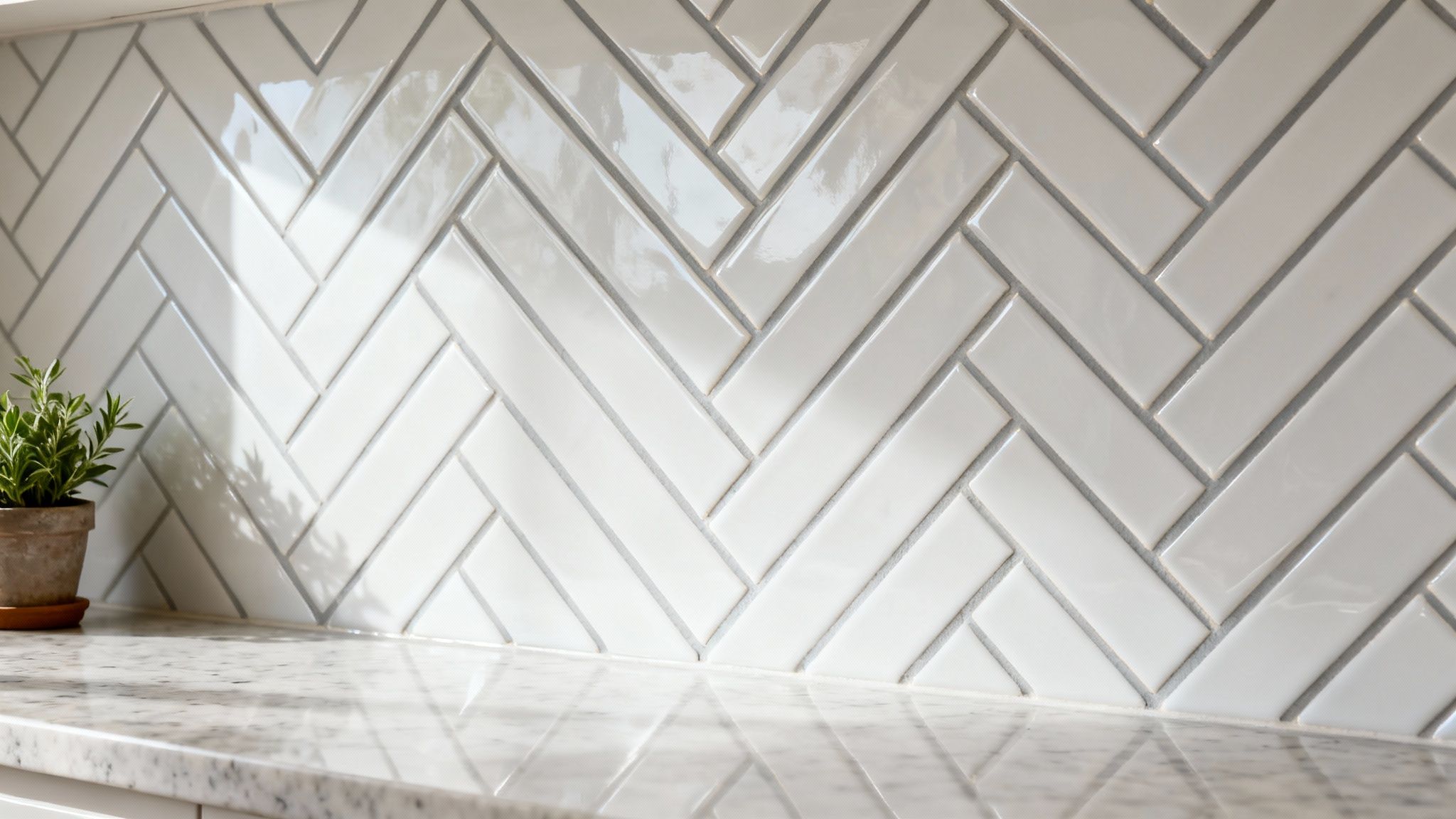 A bright kitchen features a white herringbone subway tile backsplash and granite countertop with a plant.